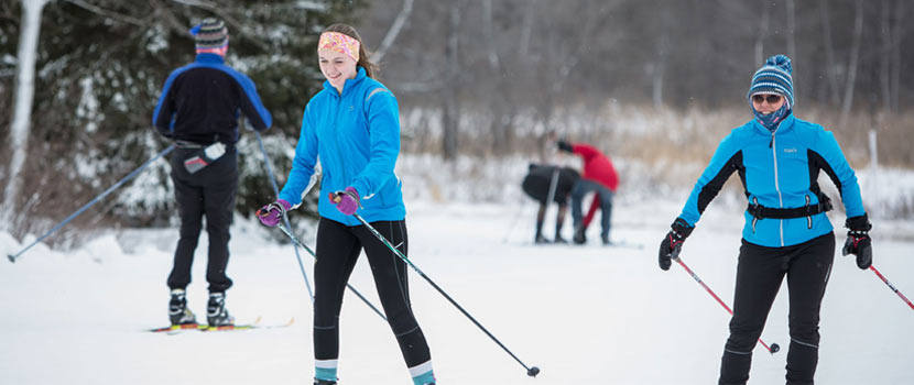 cross-country skiers smiling on the trail.