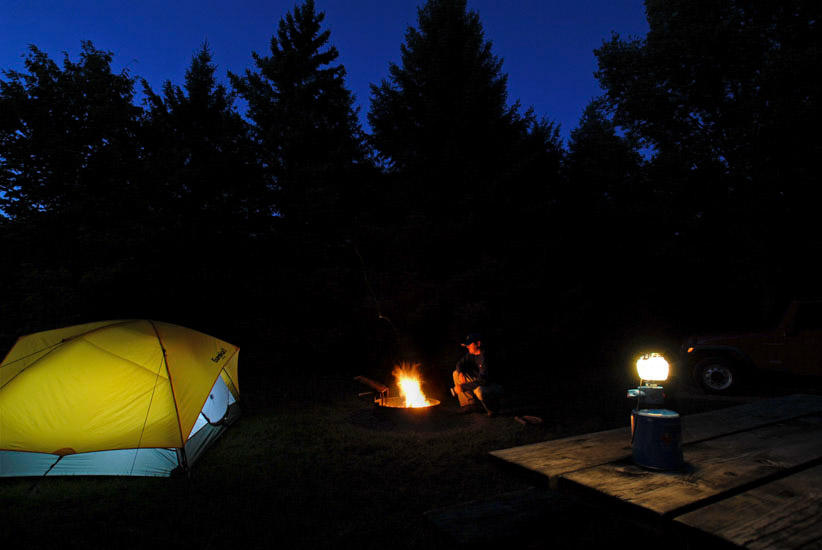 Campfire and tent at night