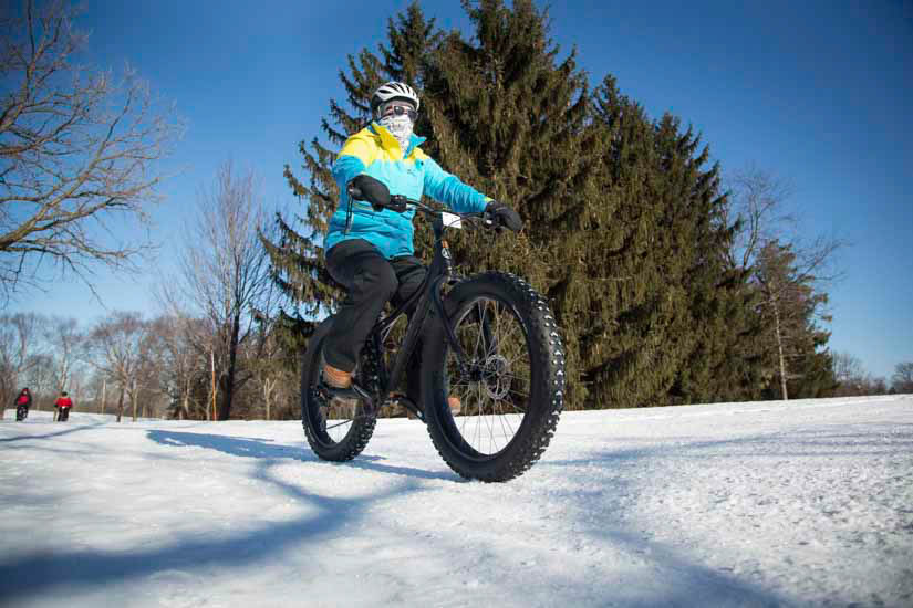 Person riding fat bike on snowy trail