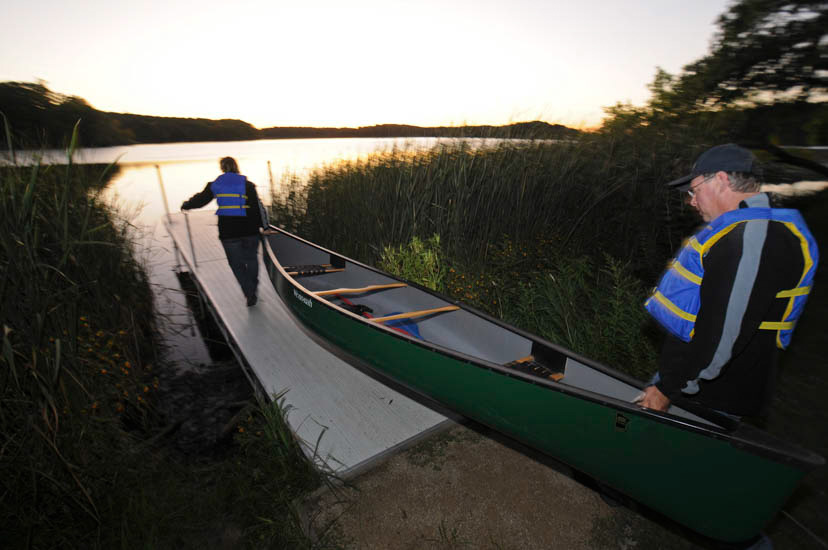 Couple carrying canoe to lake