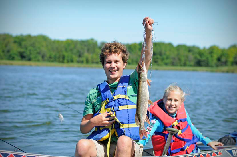 Two kids fishing from canoe
