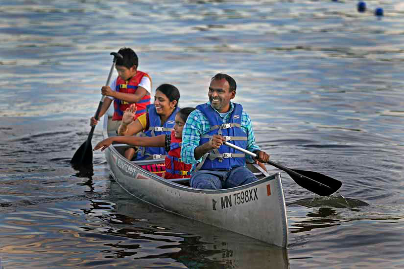 Family paddling on lake in a canoe