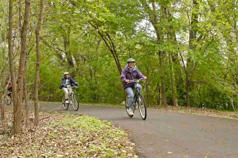 Two bikers on a paved trail