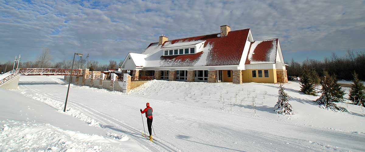 skiers glide past a large ski chalet