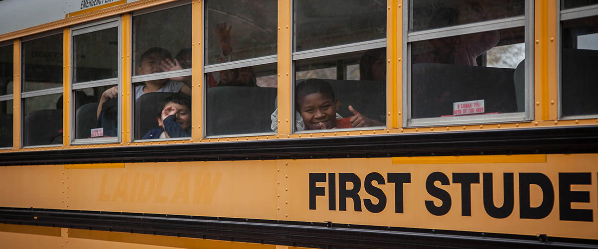 A boy looks out of a school bus window