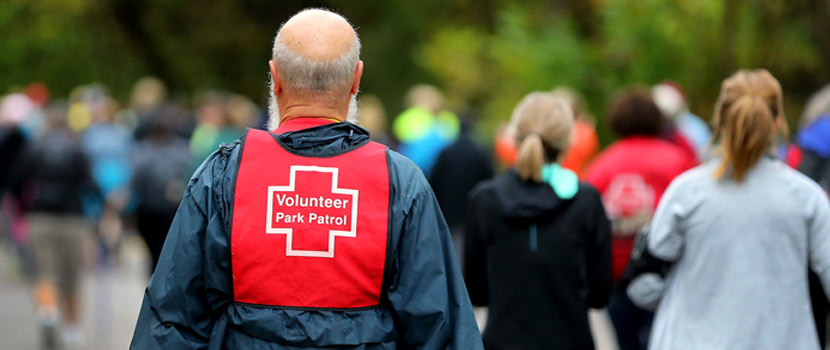 back of a volunteer wearing a red vest that says park patrol
