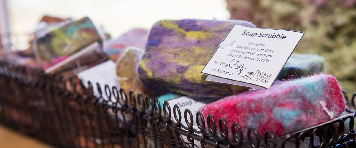 colorful wool soap scrubbies in a wire basket