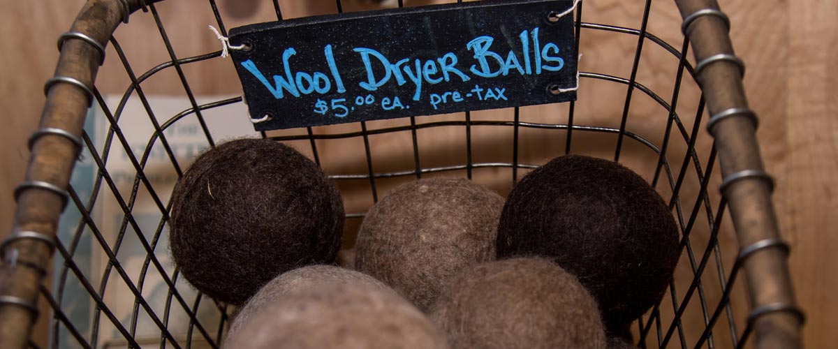 brown and tan dryer balls in a black wire basket.