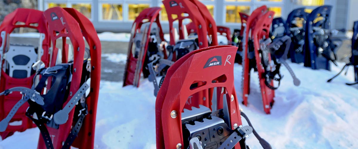 red plastic snowshoes stuck into the snow outside of a building