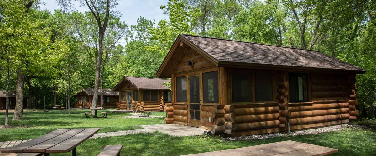 three log camper cabins on a spring day. 