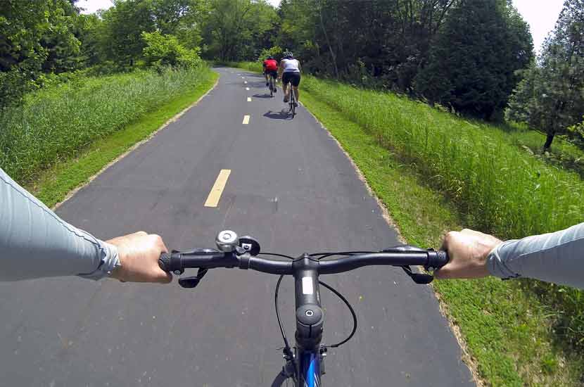 A point of view perspective of a biker on a paved regional trail.