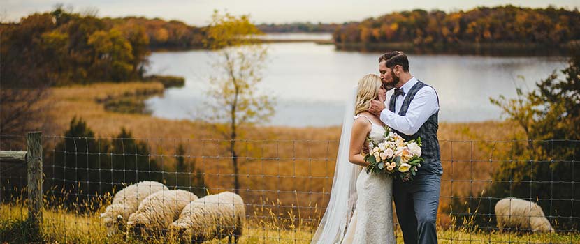 bride and groom on a fall hillside overlooking a lake