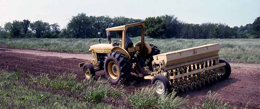 1970s tractor seed drill planting on the prairie