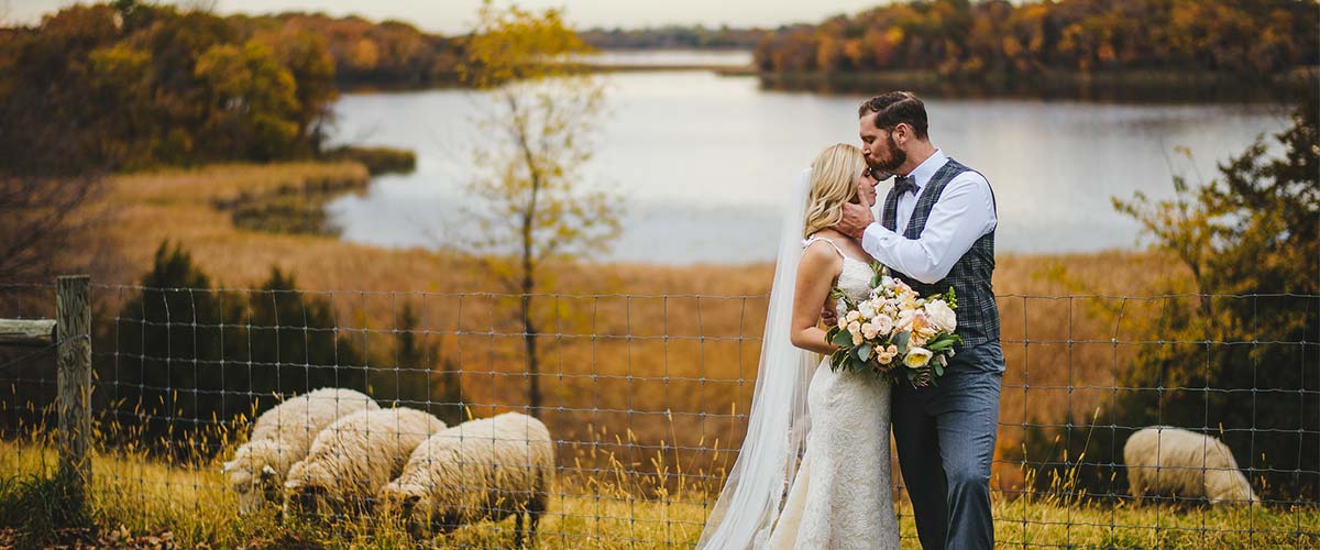 bride and groom on a fall hillside overlooking a lake