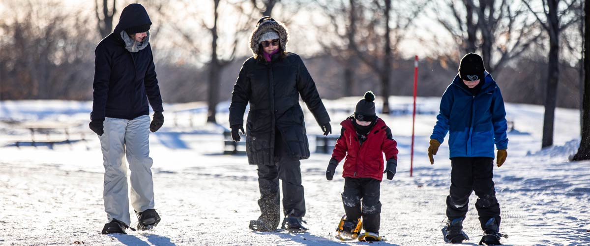 A family goes snowshoeing together.