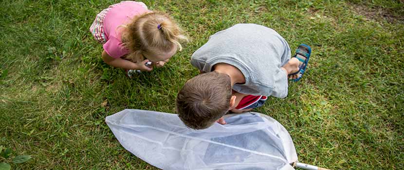 Two kids examine a net on the ground.