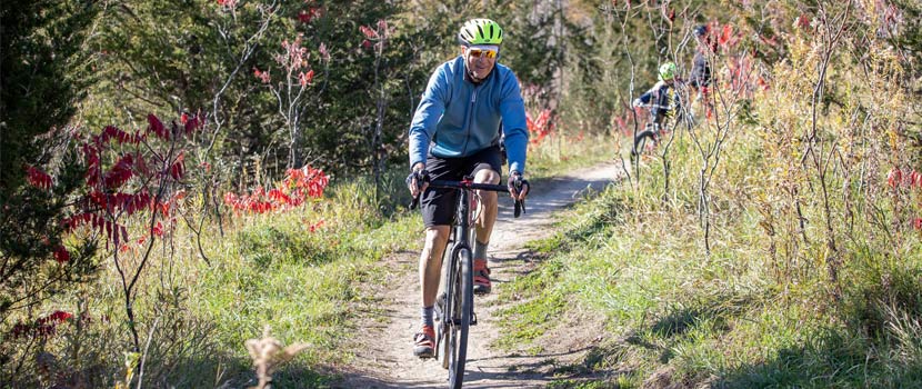 A man rides a mountain bike down a trail in the fall.