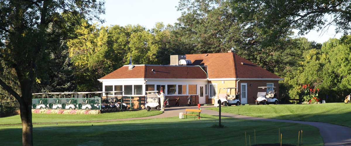 Golf carts are lined up on the back side of the Hyland Greens Golf Course clubhouse.