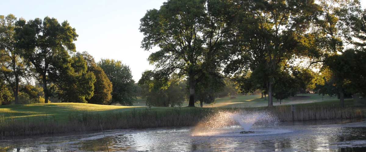 A fountain sprays water in a pond at Hyland Greens Golf Course.
