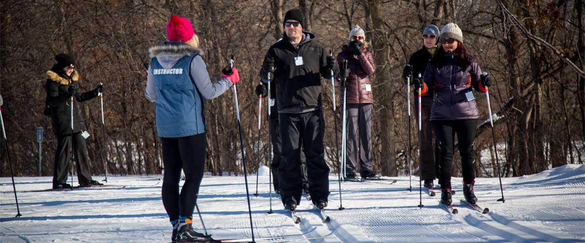 A woman teaches a cross-country ski lesson.