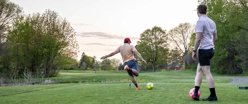 Two people play footgolf at Baker National Golf Course.