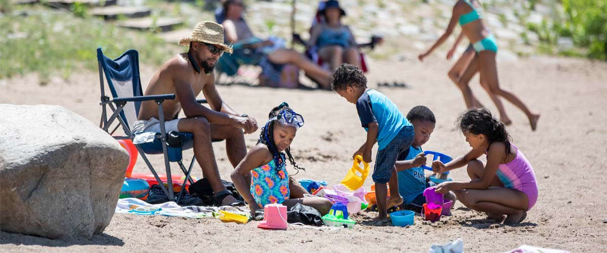 A family relaxes on a beach in the summer. 