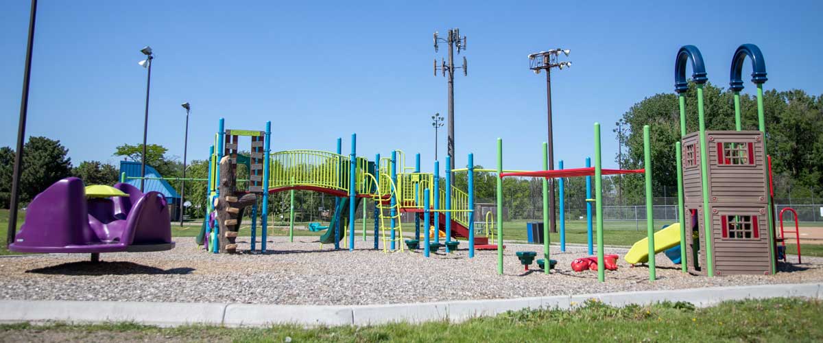A colorful play area including a merry-go-round, slides and bridge.