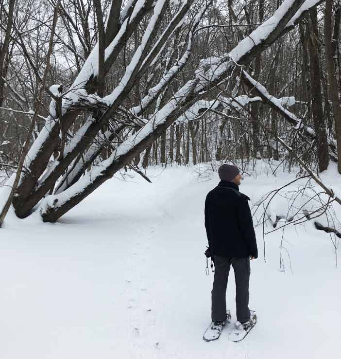 man in snowshoes in a wintry woods