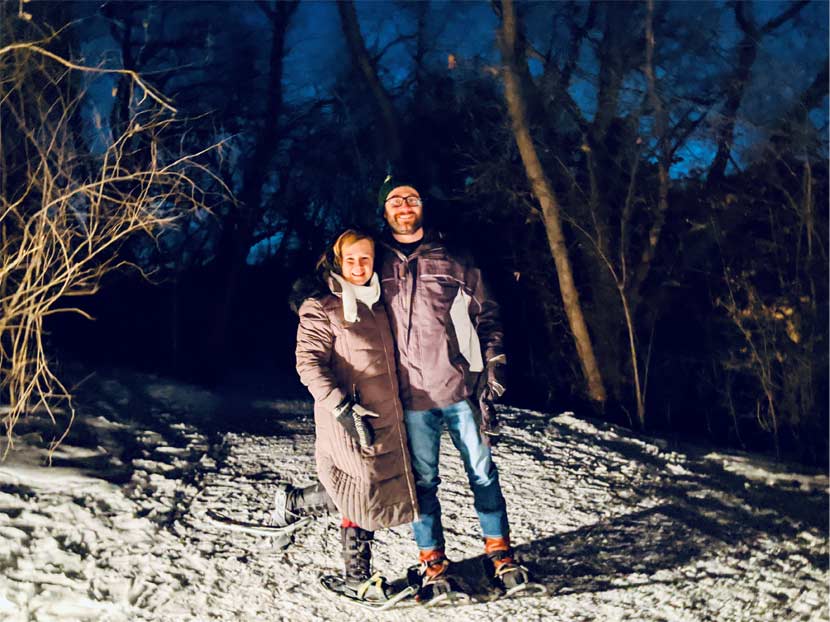 Beth and her husband post for a photo while snowshoeing at night at French Regional Park.