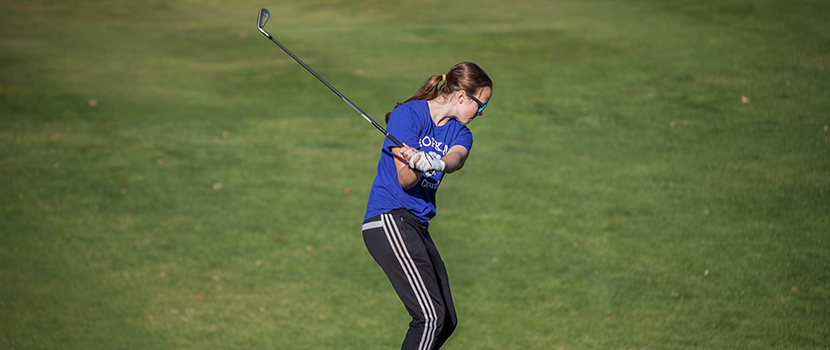 A girl takes a swing with a golf club