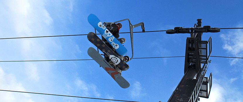 Looking up at the bottom of snowboards on the chairlift