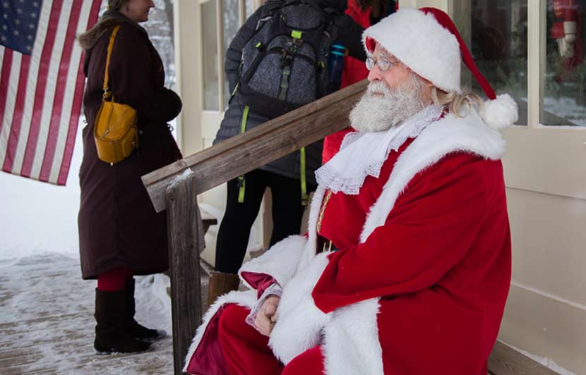 a man dressed as Santa Claus sitting on a front stairway
