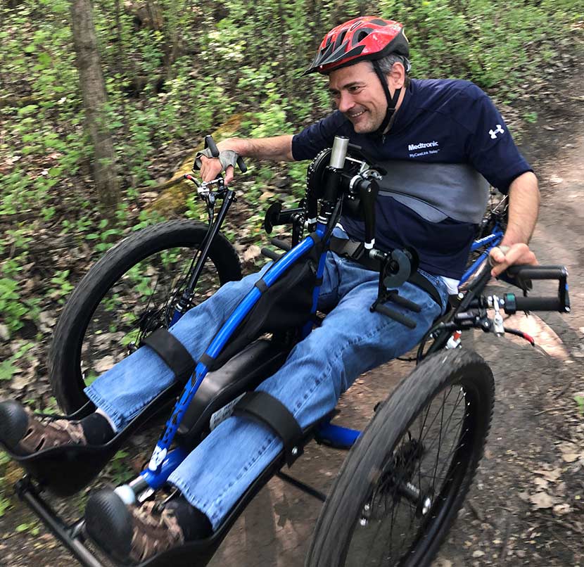 Steve Laux maneuvers his adapted handcycle with electronic assist on the dirt singletrack, winding between trees. Photo by Nick Sacco.