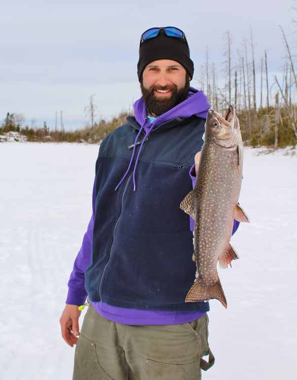 Nick Sacco holds up a brook trout caught while ice fishing.