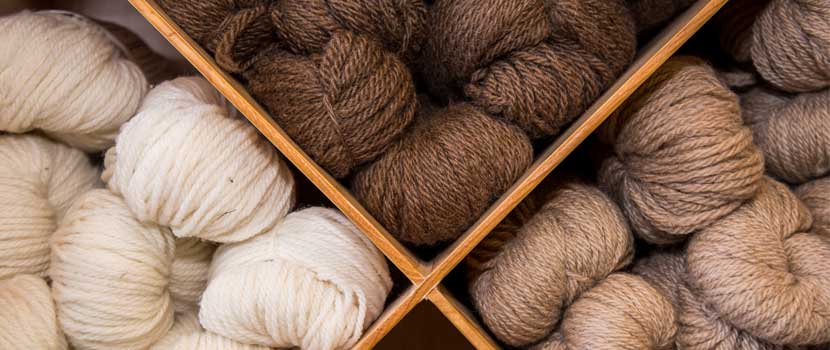 white, brown and tan yarn on a shelf