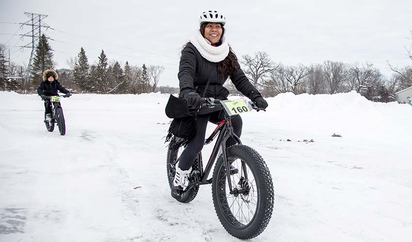 woman on a fat bike riding through snow