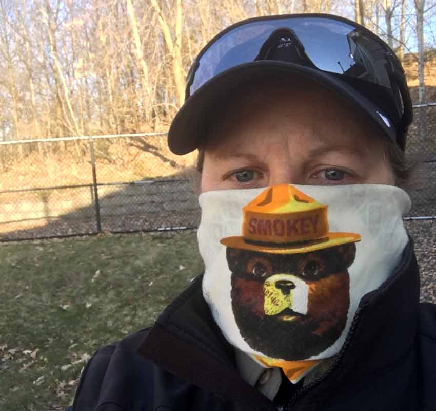 Selfie of Lori wearing a Smokey the Bear face mask.