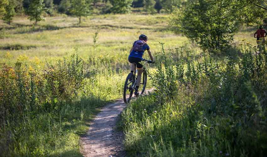 mountain biker on a singletrack trail through prairie