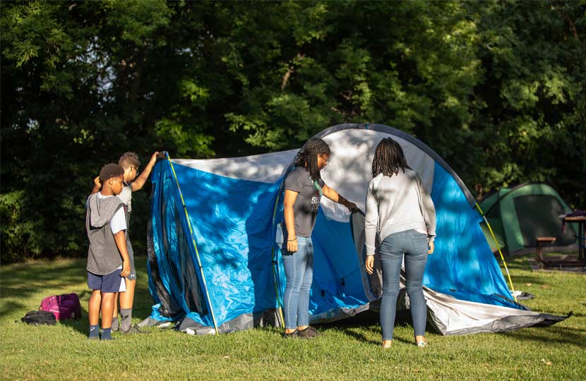 Two women and two boys set up a tent at Baker Campground.