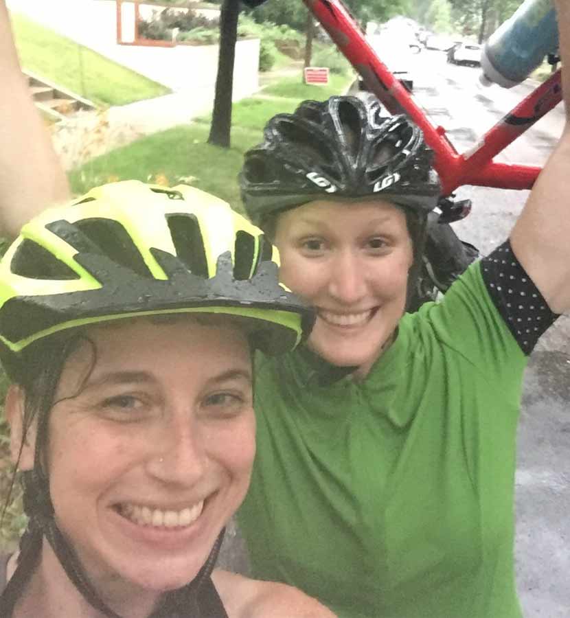 Andrea and Jessica biking in the rain