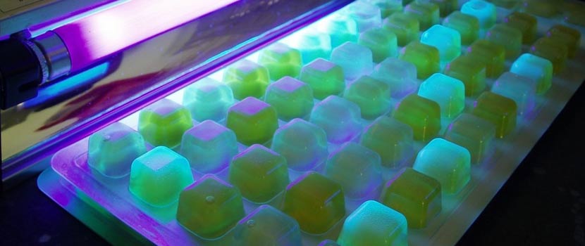 tray of e.coli water samples under a black light