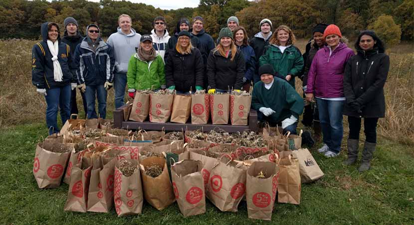 volunteer seed collectors posing for a picture with bags of collected seeds.
